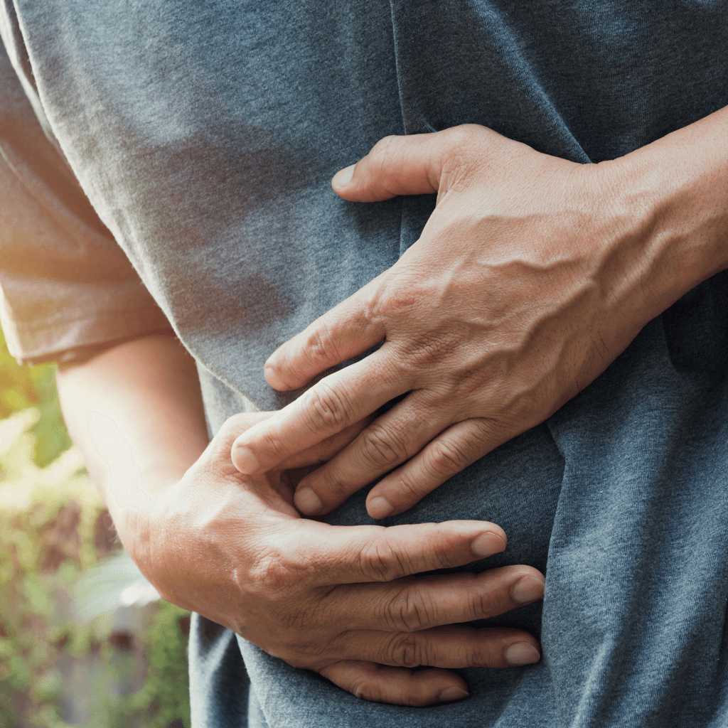 Mann hält sich Hände an den Bauch