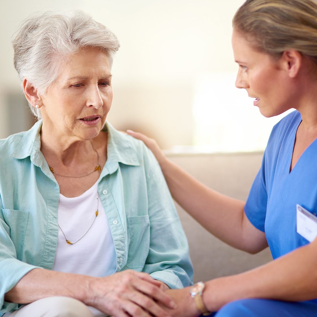 Arzthelferin im Gespräch mit älterer Frau